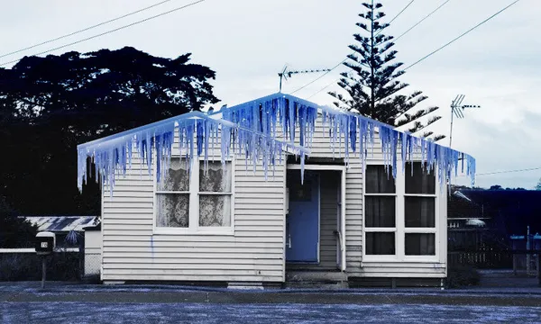 a white wooden house with blue icicles digitally added