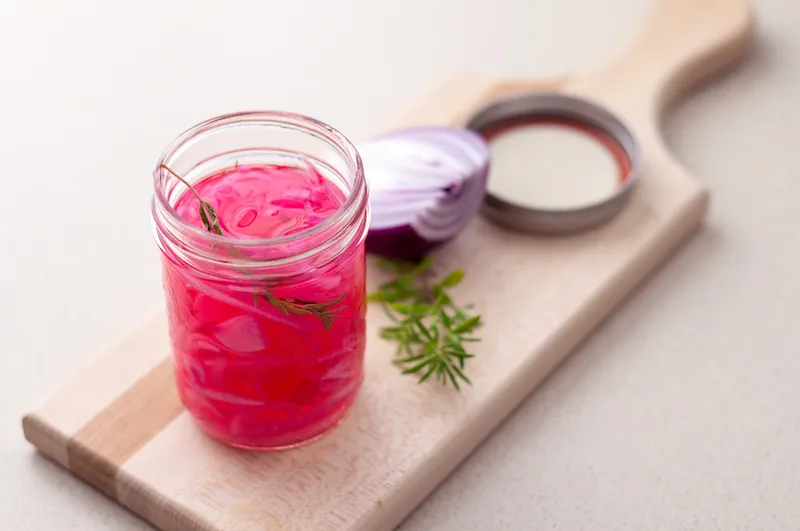 Pickled onions in a glass jar.