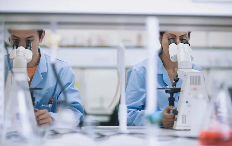 Scientists working in laboratory with microscopes