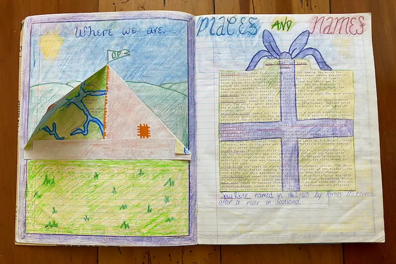 A spread of an old school work book, showing beautifully coloured-in projects on Fiordland, including a pup tent with flaps that open.