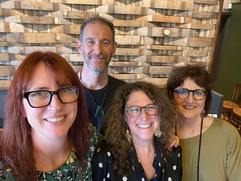Selfie of four smiling people, three women and one man.