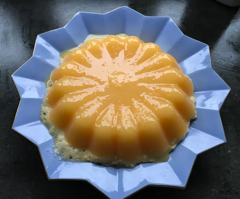 Glossy orange jelly on a blue star-shaped plate.