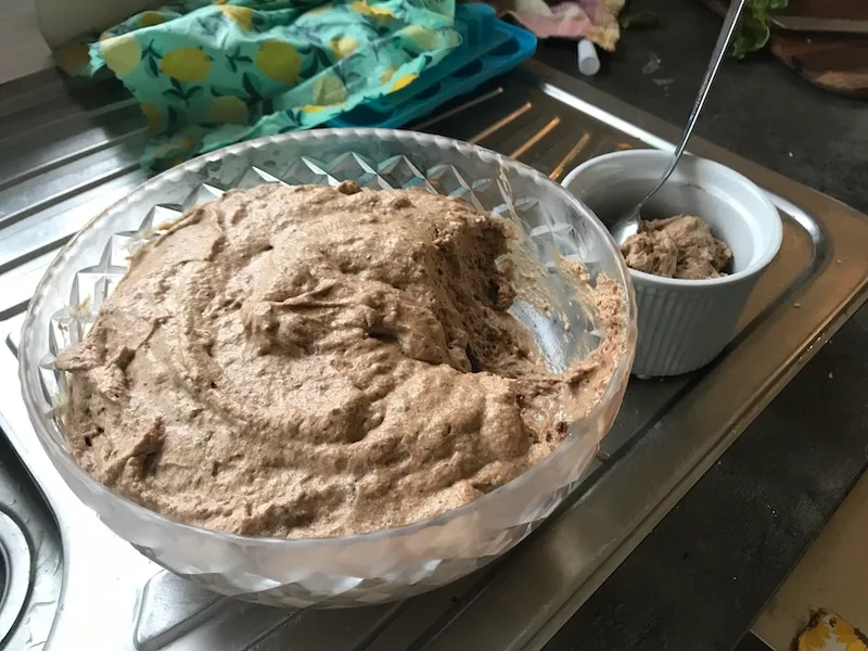 Cut-crystal bowl full of chocolate mousse, with one scoop in a ramekin beside.