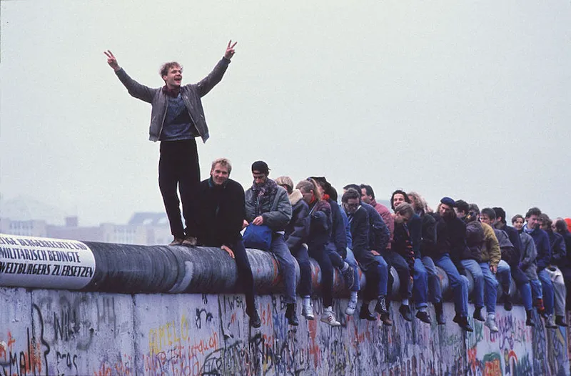 West Germans Celebrate The Unification Of Berlin Atop The Berlin Wall During The Collaps