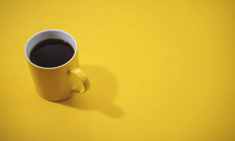Yellow Coffee Mug on Yellow Background.