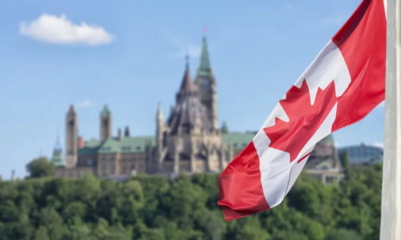 Canadian flag waving with Parliament Buildings hill and Library