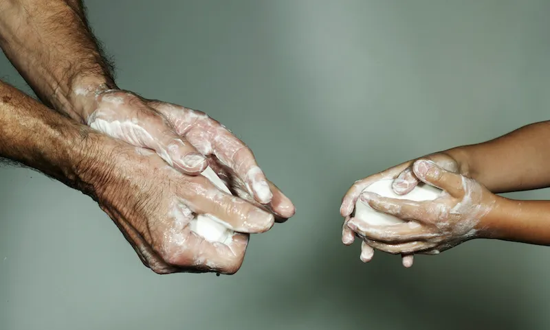 Grandfather and grandson (6-7) washing hands with bar of soap, close-up