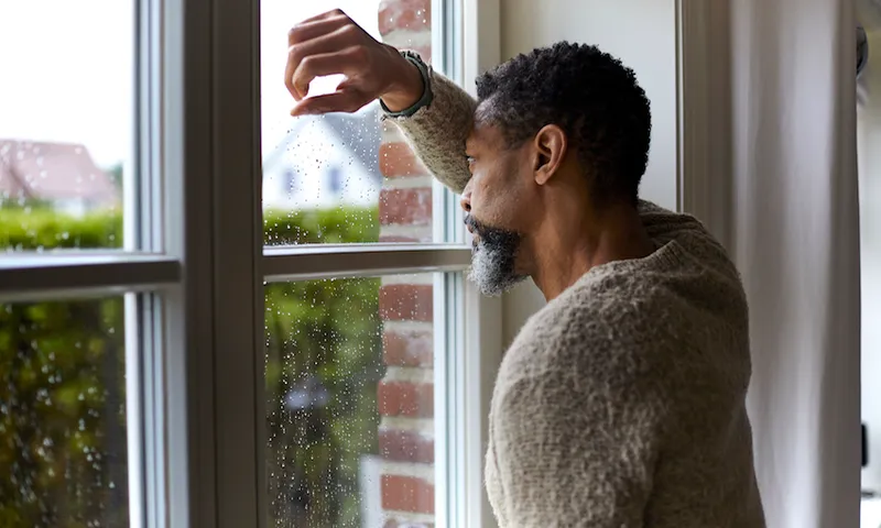Pensive man looking out of window