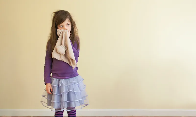 Sick Caucasian girl wiping nose
