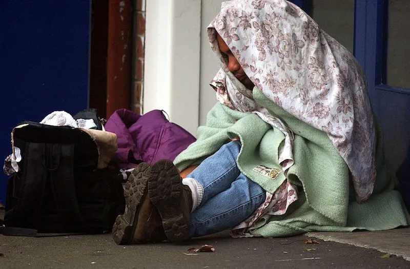 A homeless man keeps warm in the doorway of a cent