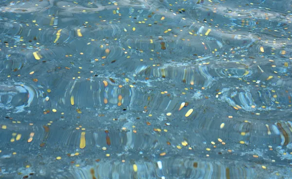 Coins in fountain, view through water, full frame