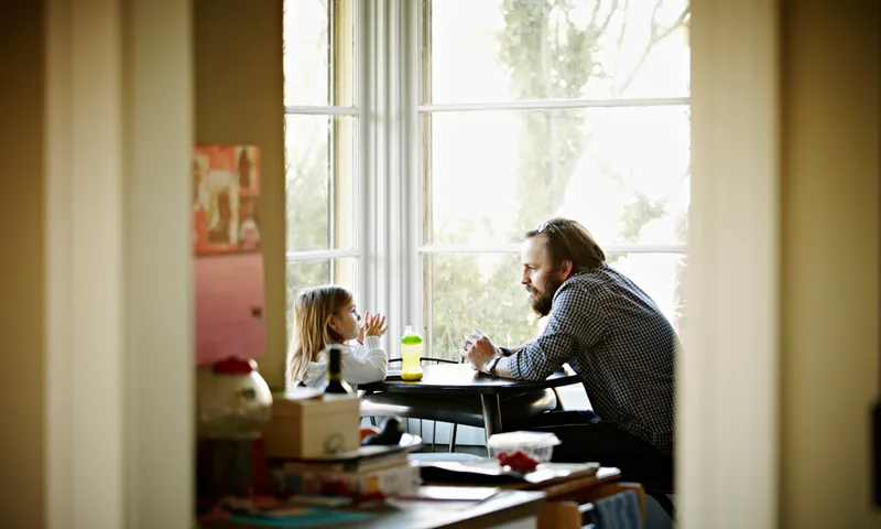 Father and daughter sitting at table in discussion