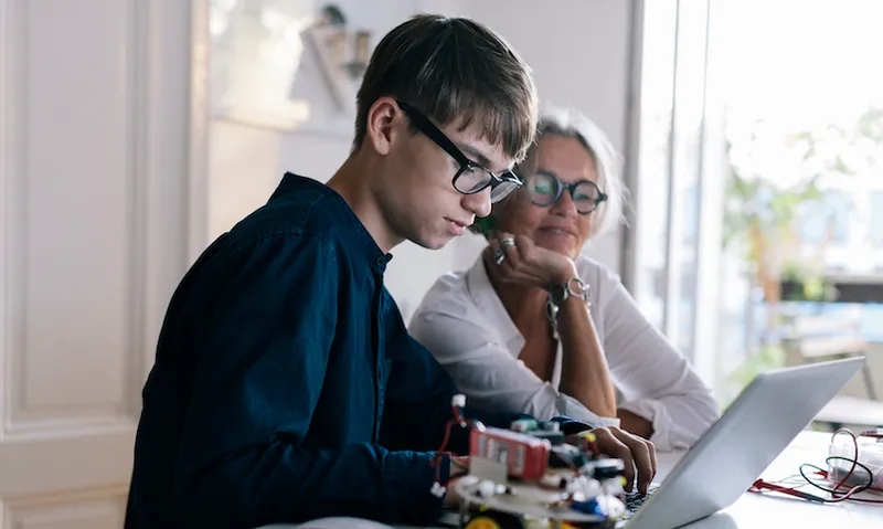 Mother helping son with computer coding