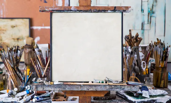Blank art canvas in mess artist’s studio