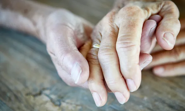 Senior couple holding hands, close-up