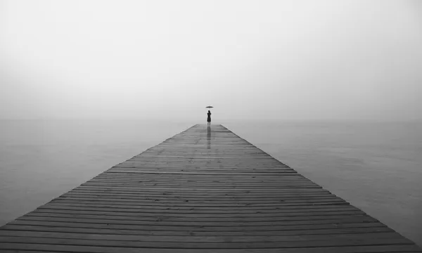 woman with black umbrella looking infinity in a surreal place