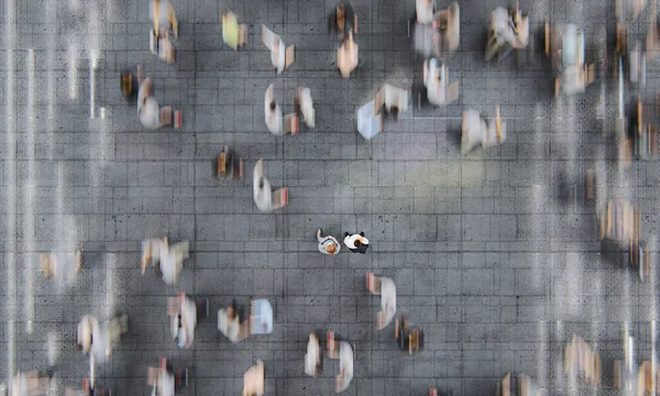 Businessman standing in the fast moving crowds of commuters