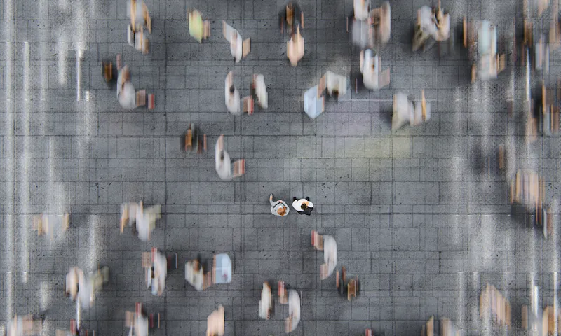Businessman standing in the fast moving crowds of commuters