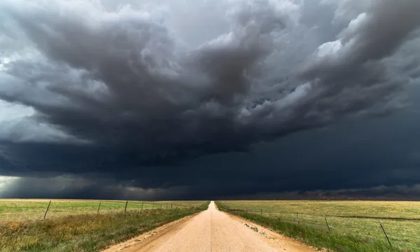 Dark storm clouds over a dirt road