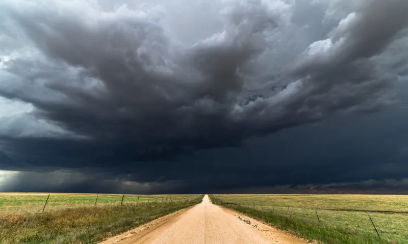Dark storm clouds over a dirt road