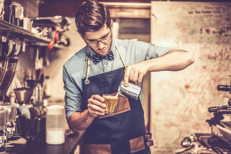 Young barista is making a coffee