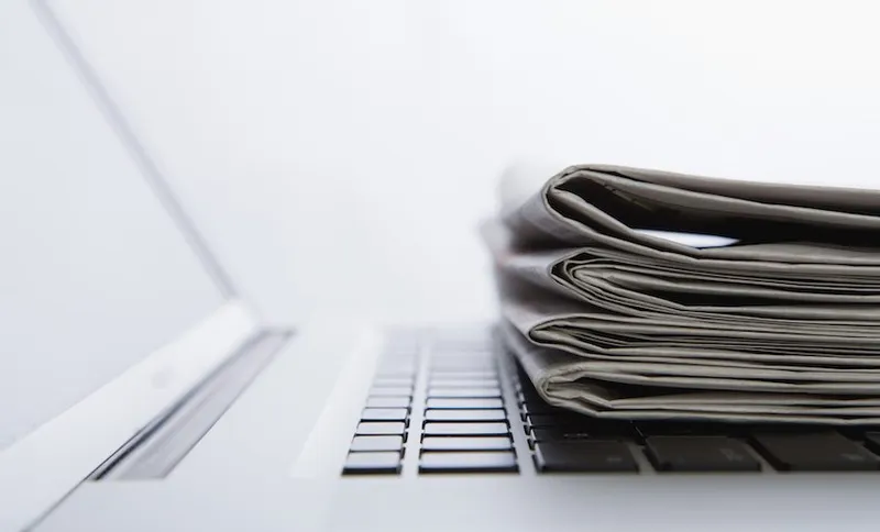 Stack of newspapers on laptop. close-up