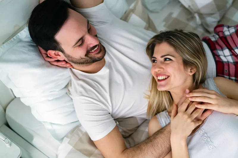 Young attractive couple having romantic time in bed