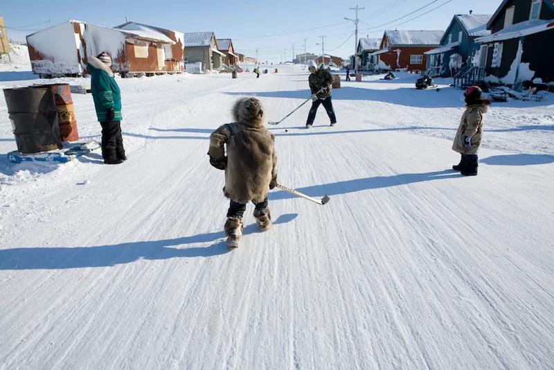 Inuit children playing ice hockey