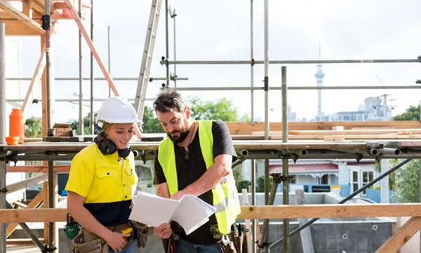 male and female construction workers discuss the building plans on the building site