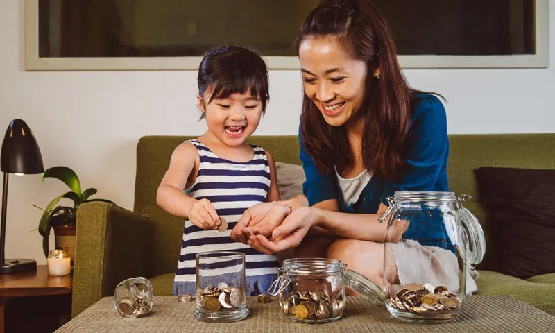 Mom & child putting coins into glass jars