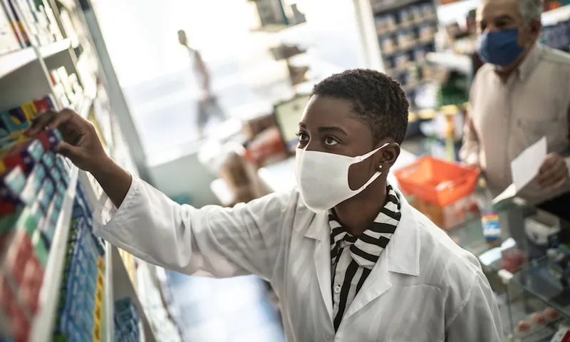 Female pharmacist giving medications to senior customer