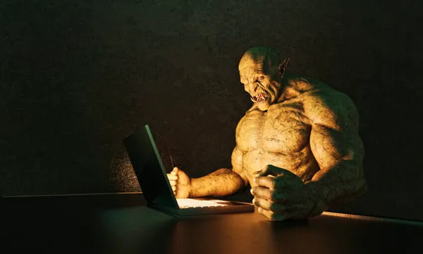 Internet troll: angry ogre pounding fists on desk while using laptop computer