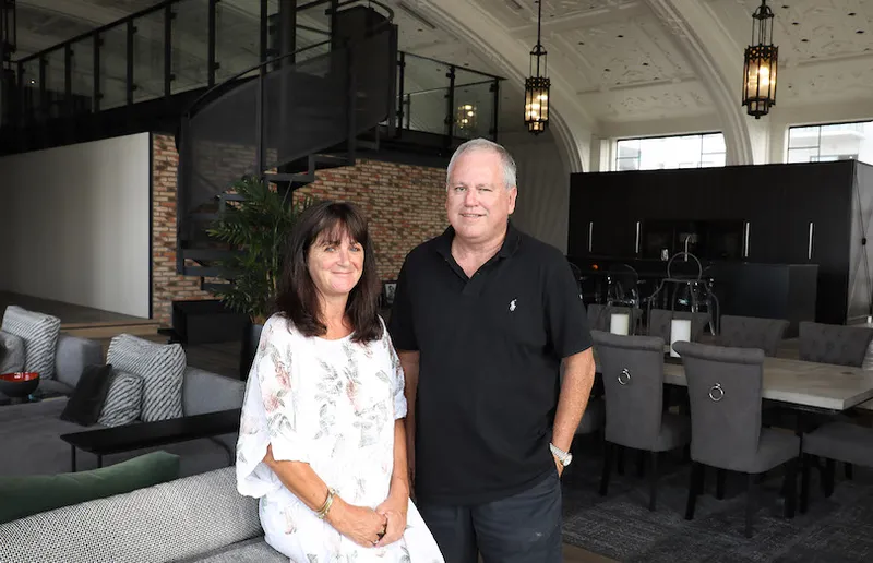 A man and woman standing in their renovated apartment