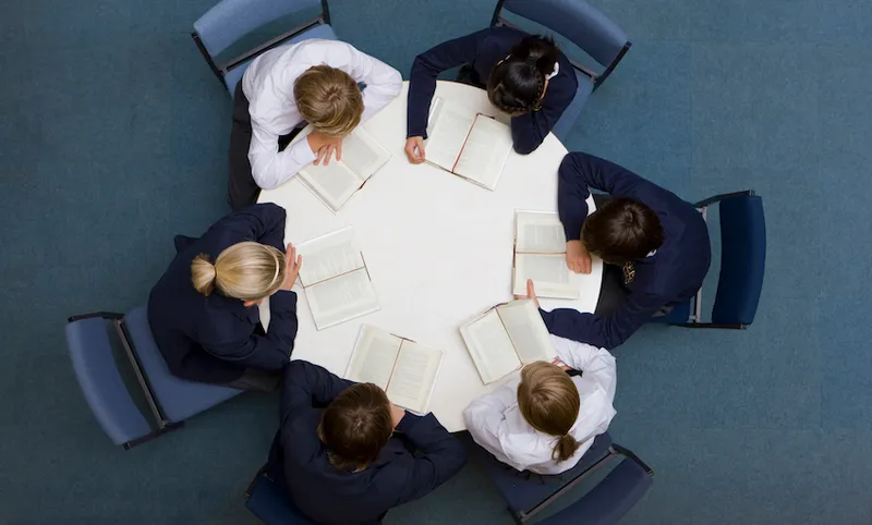 Students reading at round table in school library