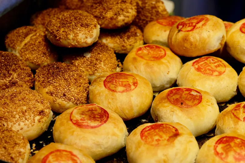close up fresh pork moon cakes (meat-stuffed) under warm yellow light.