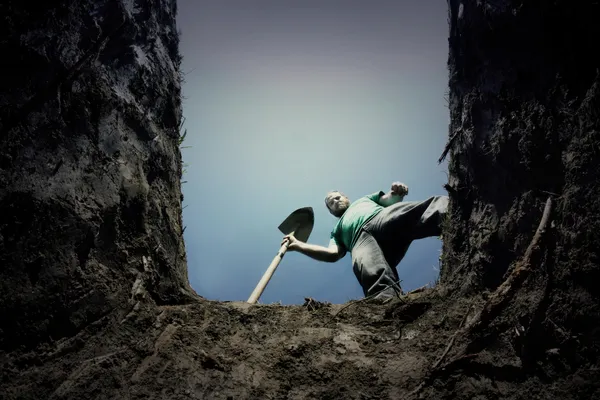 Man looking into a grave