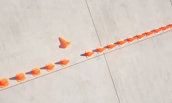 Row of traffic cones with one on side