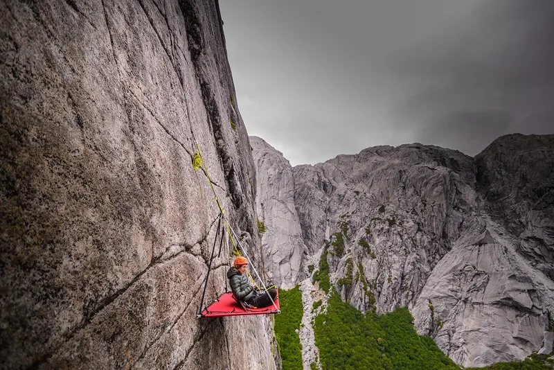 Woman sitting on portaledge, Cochamo, Los Lagos, Chile
