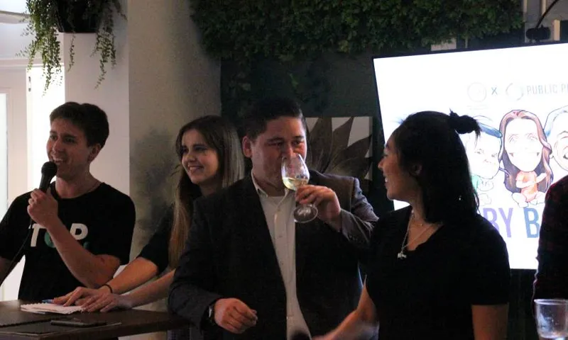 young politicians face off at a baby back benches event - focus is on Jay McLaren-Harris, who is sipping from a glass of white wine