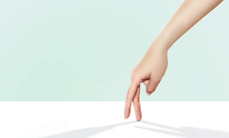 hands walking across a bright white surface