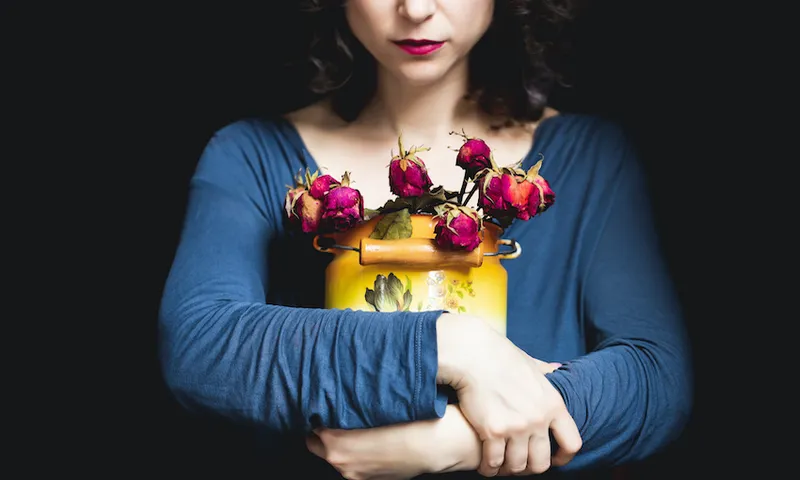 Woman holding wilted roses