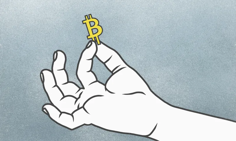 Cropped hand of man holding Bitcoin symbol against gray background