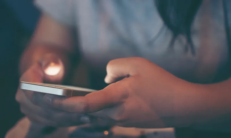 Midsection Of Woman Using Phone In Darkroom