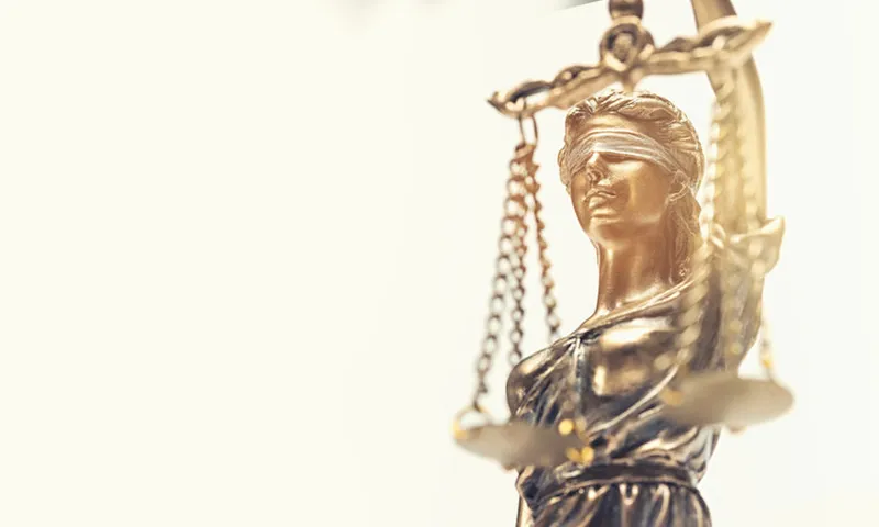 Close-Up Of Lady Justice Against White Background