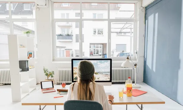 Back view of freelancer working at desk in a loft