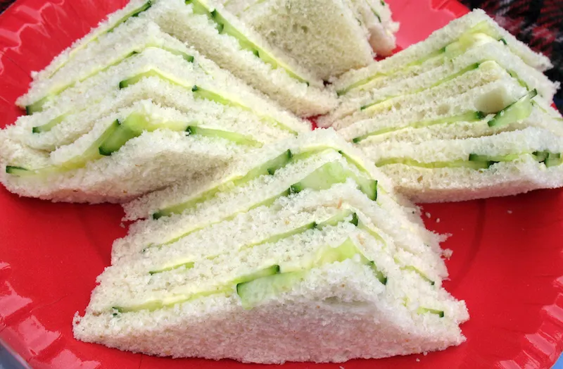 Cucumber sandwiches on a red paper plate at a picnic