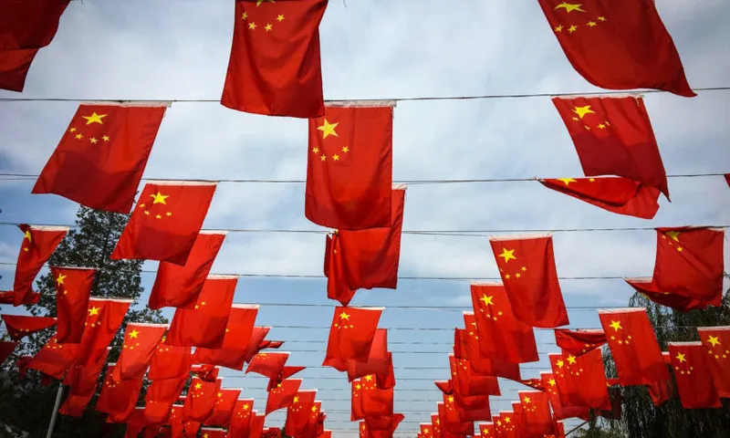 Low Angle View Of Chinese Flags Hanging Against Sky