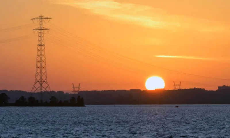 sun powerlines over water generic getty images