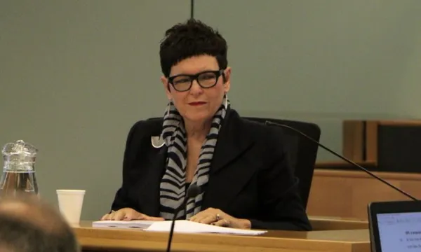 jenny shipley in a black blazer and stripey scarf