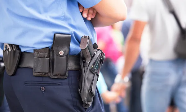 Midsection Of Police With Handgun Standing Outdoors